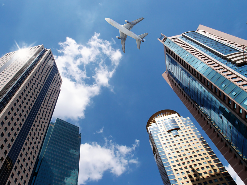 airplane flying over buildings